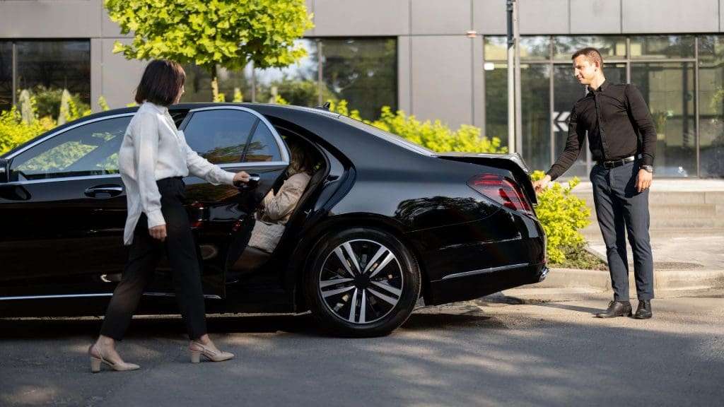 Chauffeurs loading luggage, woman closing car door, Gold Coast transportation