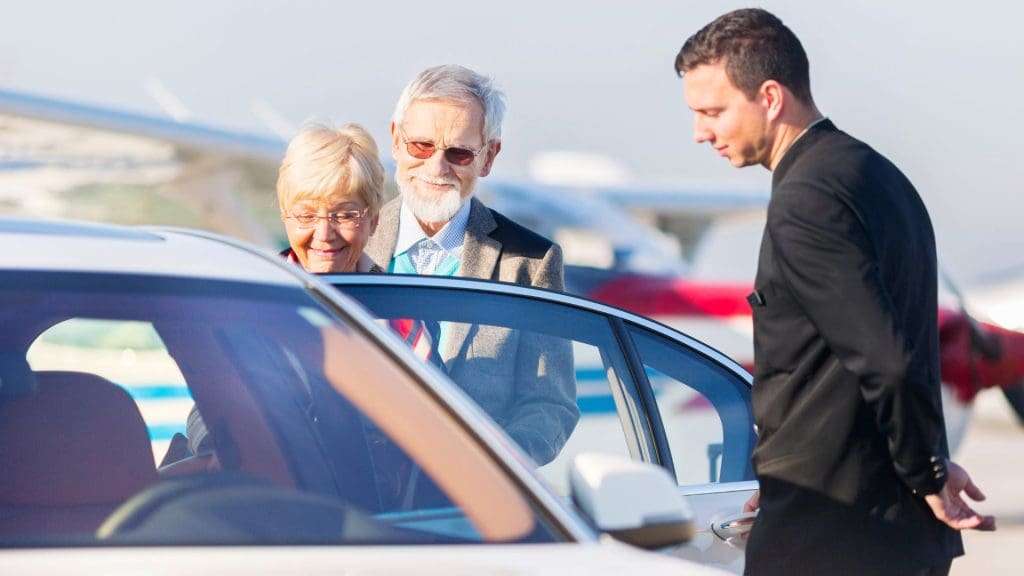 Elderly couple sitting in car for holiday transfer Queensland.