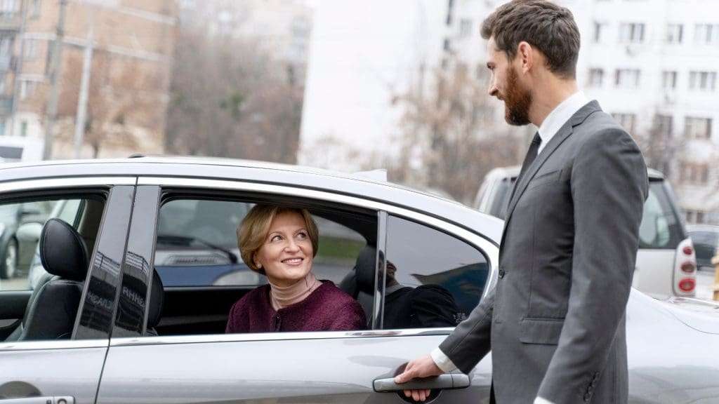 Corporate Chauffeur Service helping client exit vehicle