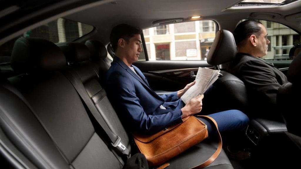 Luxury car hire chauffeur driving executive passenger safely